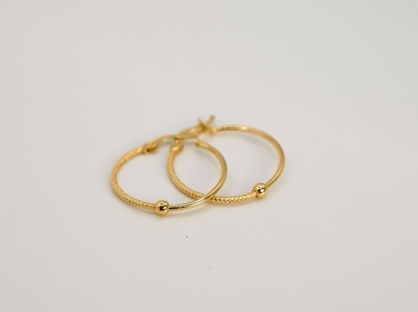 14 karaat gouden hoepelvormige oorbellen met een uniek design