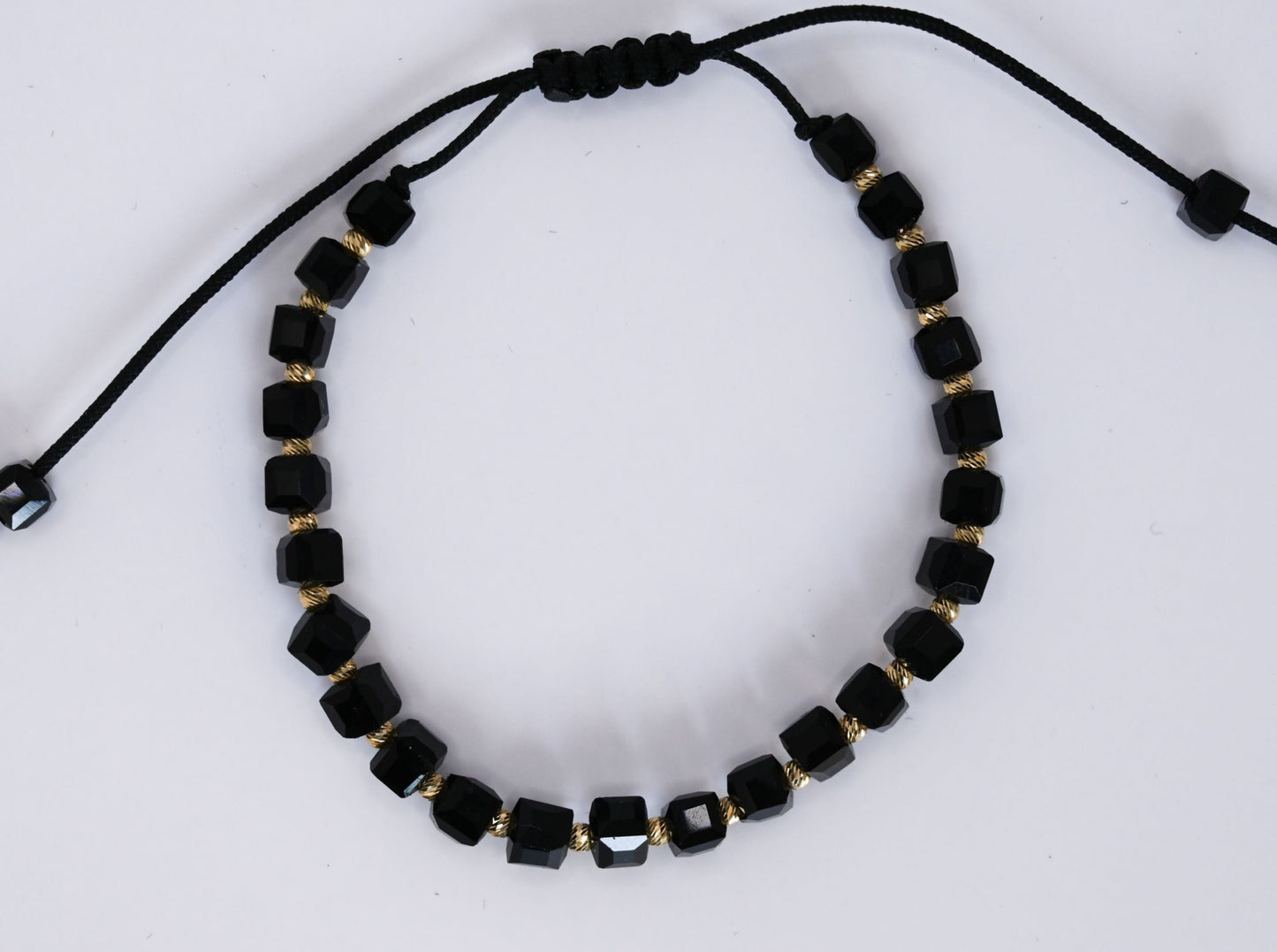 Een unieke, krachtige armband met 14 karaat gouden vierkante kralen