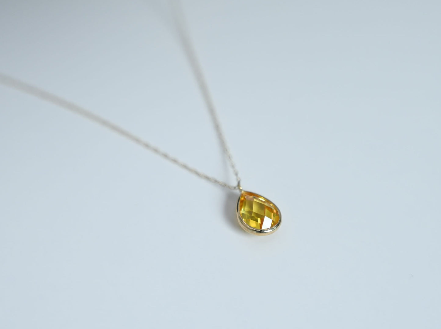 14 karaat gouden ketting met een druppelvormige, gele hanger
