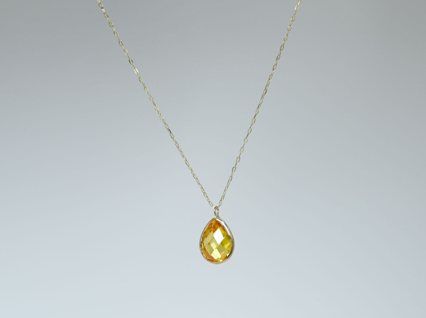 14 karaat gouden ketting met een druppelvormige, gele hanger