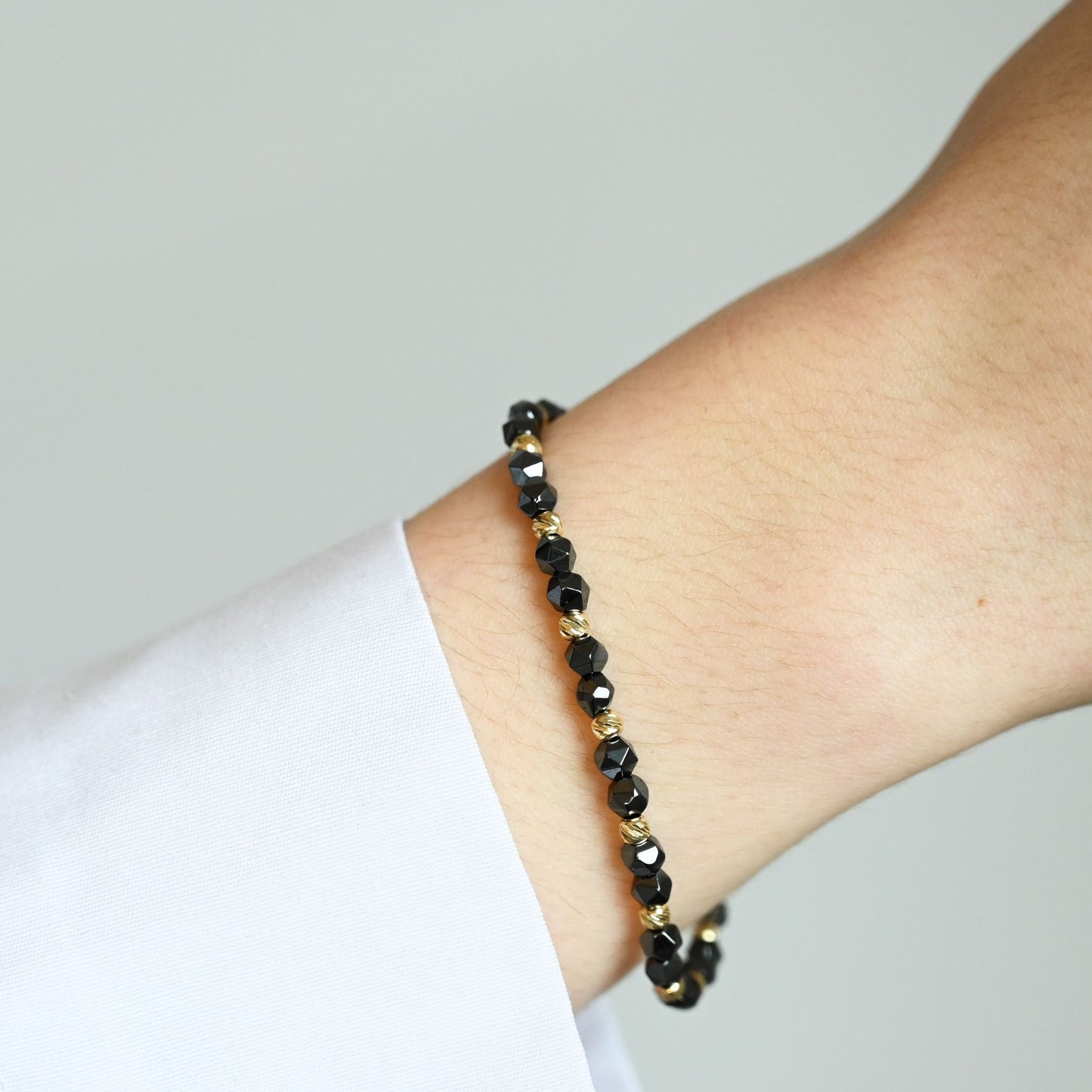 Een unisex kralenarmband met keramische kralen en 14 karaat gouden kralen.&nbsp;