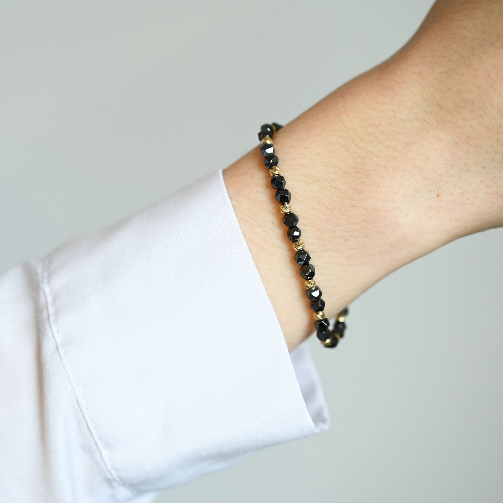 Een unisex kralenarmband met keramische kralen en 14 karaat gouden kralen 