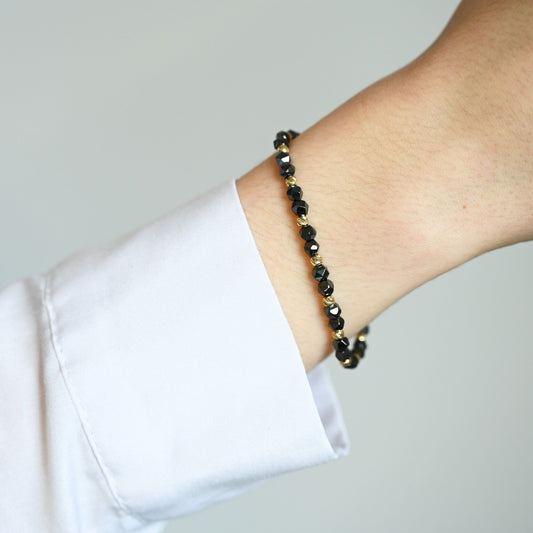 Een unisex kralenarmband met keramische kralen en 14 karaat gouden kralen 