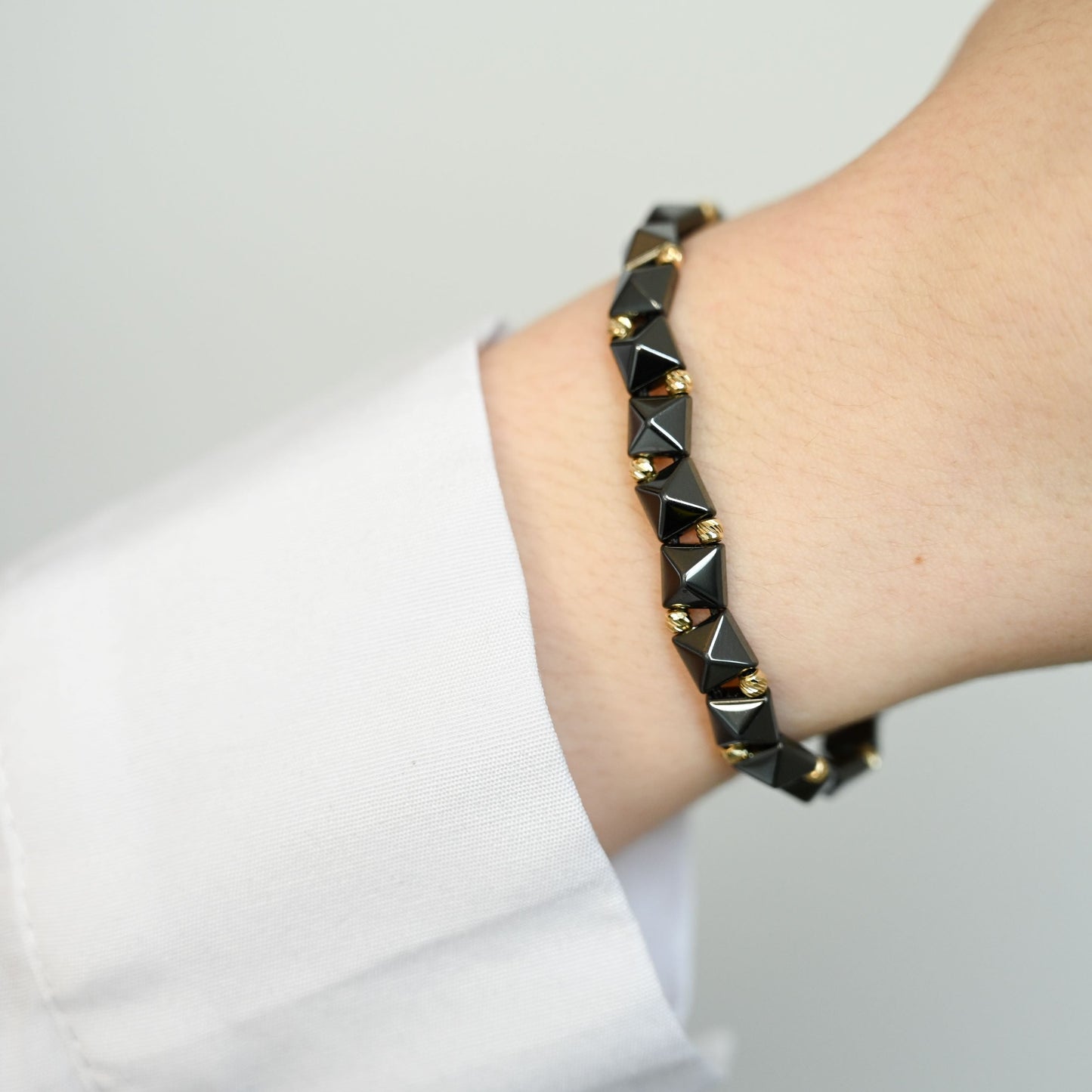 Rebellion II Gouden kralenarmband met geometrische keramische kralen